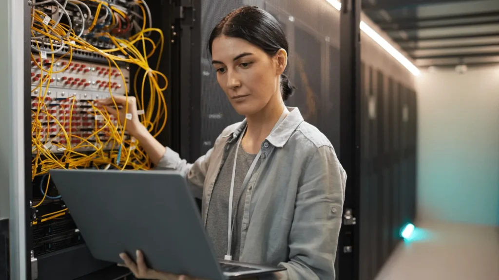Technician checking network cabling for managed IT services at a construction site