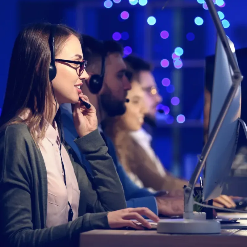 Support staff working side by side at monitors in an operations room