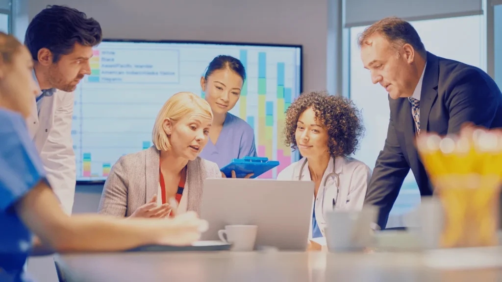 Clinic staff and care team reviewing information on a laptop