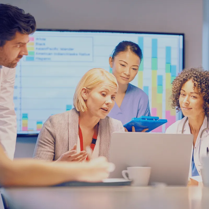 Care team members at a medical practice reviewing information on a laptop